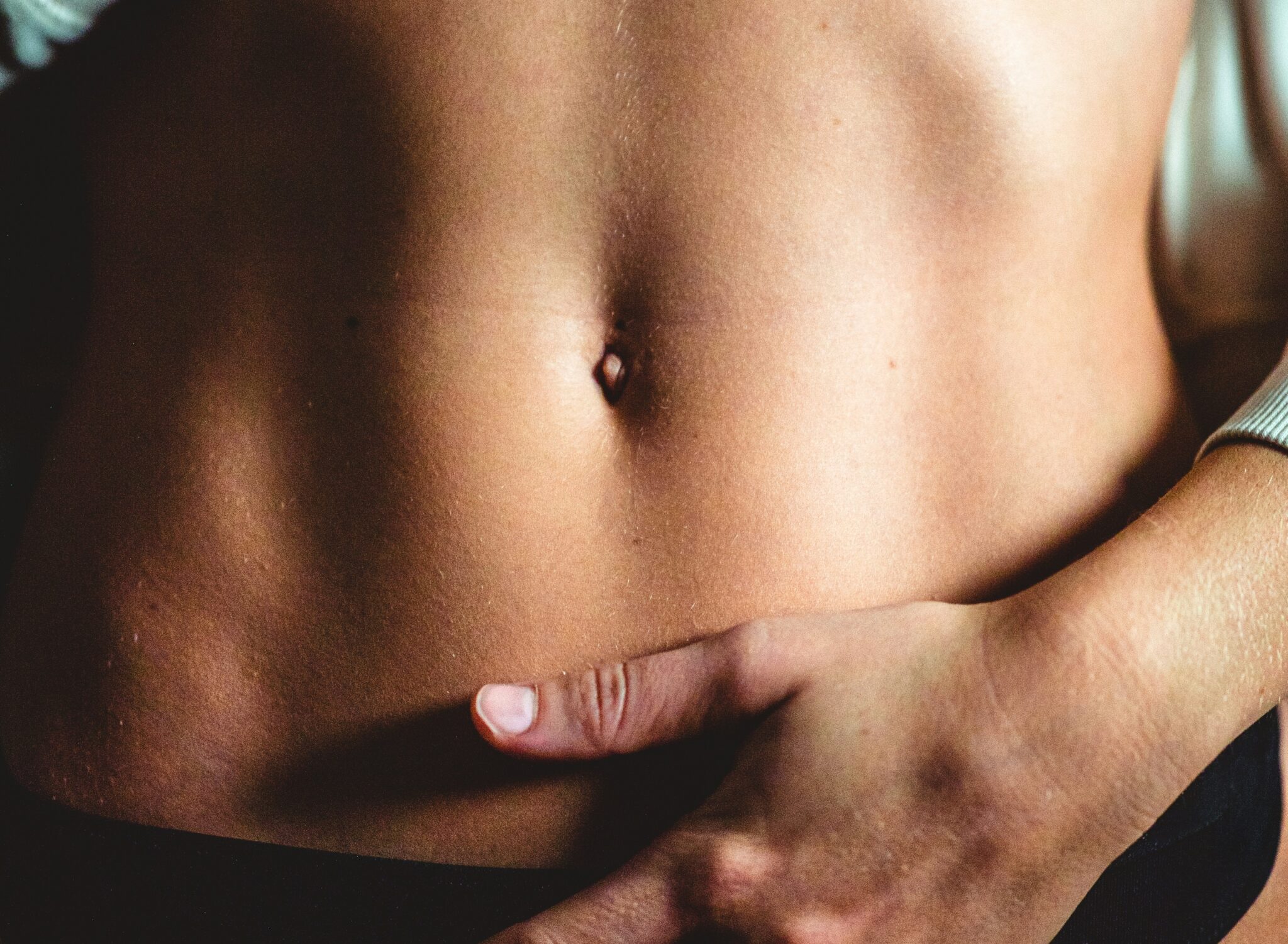 Frau hält sich den Bauch für bessere Verdauung und Darmgesundheit